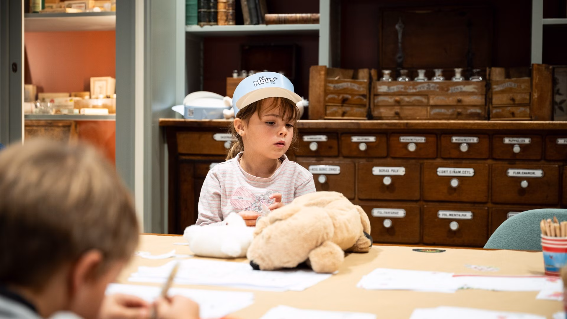 Lernen beim Türöffner Tag Kind sitzt am Tisch und beschäftigt sich mit Materialien und Spielzeug