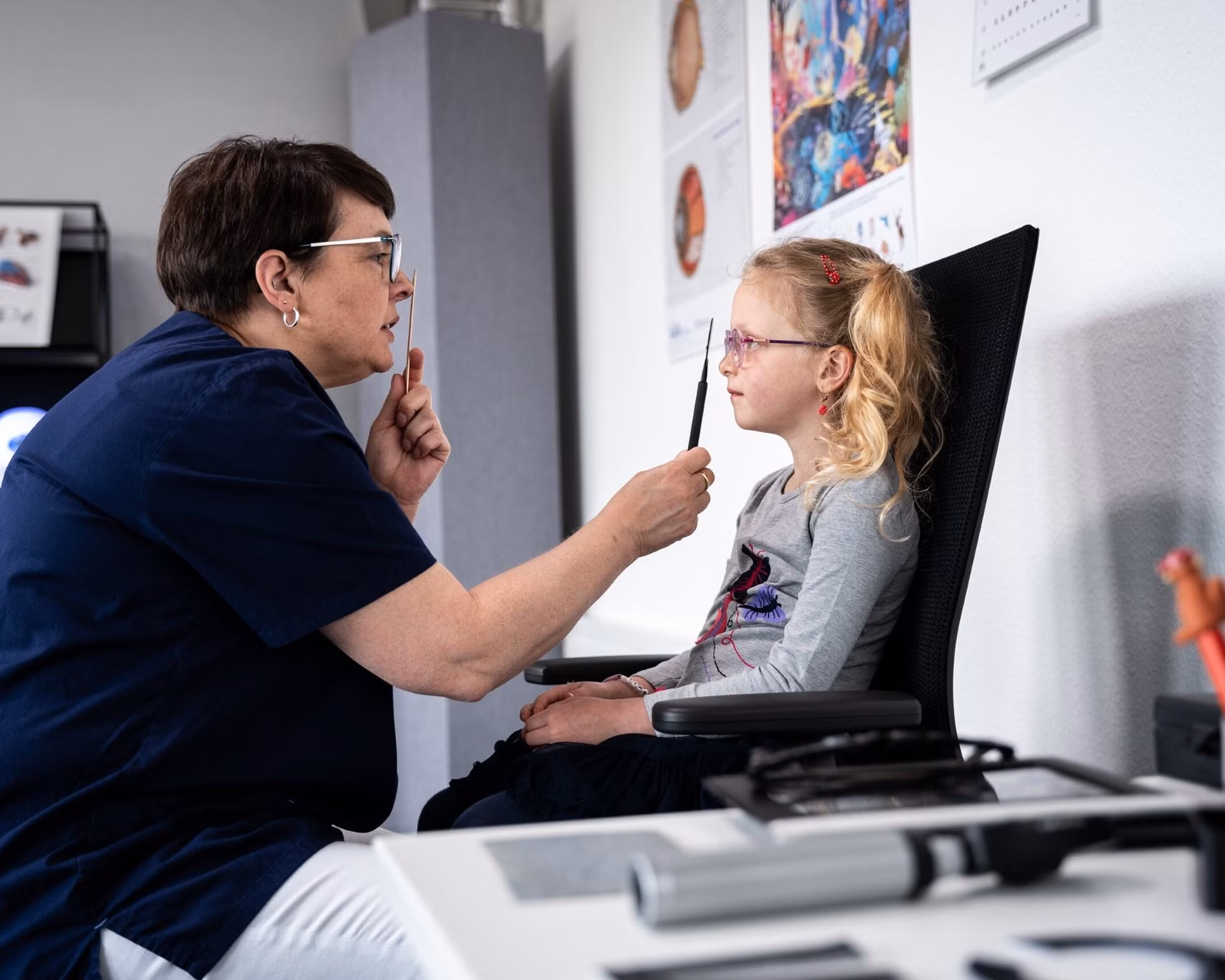 Orthoptistin in der Sehschule untersucht Kind