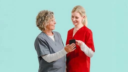 Eine Frau zeigt einer anderen etwas auf dem Smartphone.