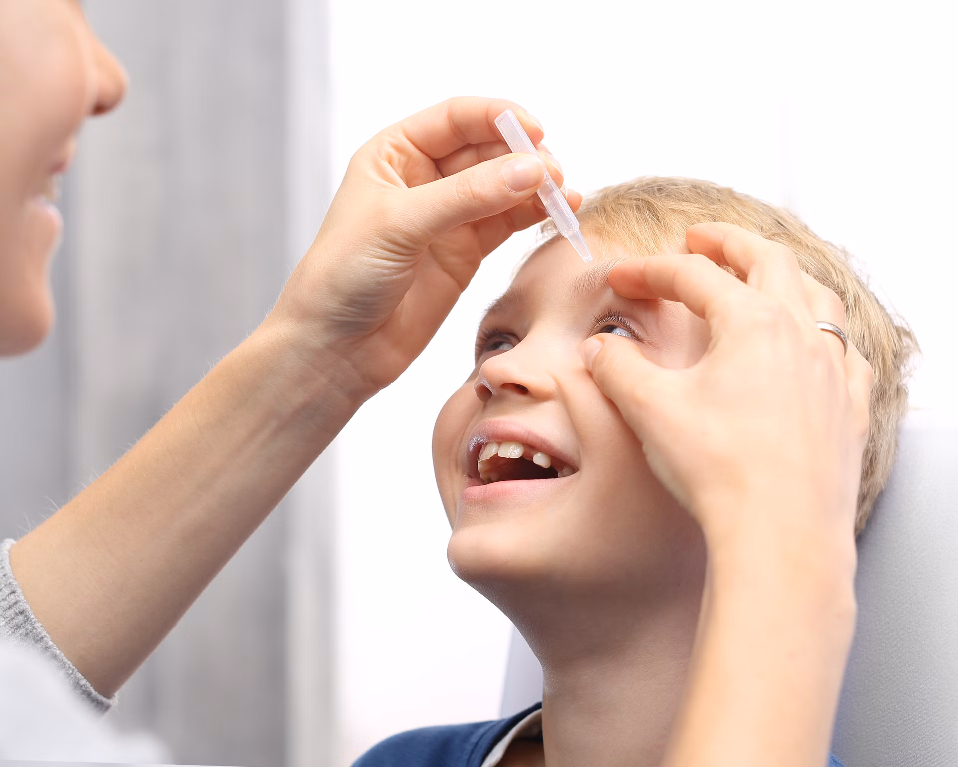 Kind bekommt Augentropfen verabreicht