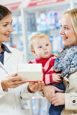 Mutter mit Kleinkind wird in der Apotheke beraten