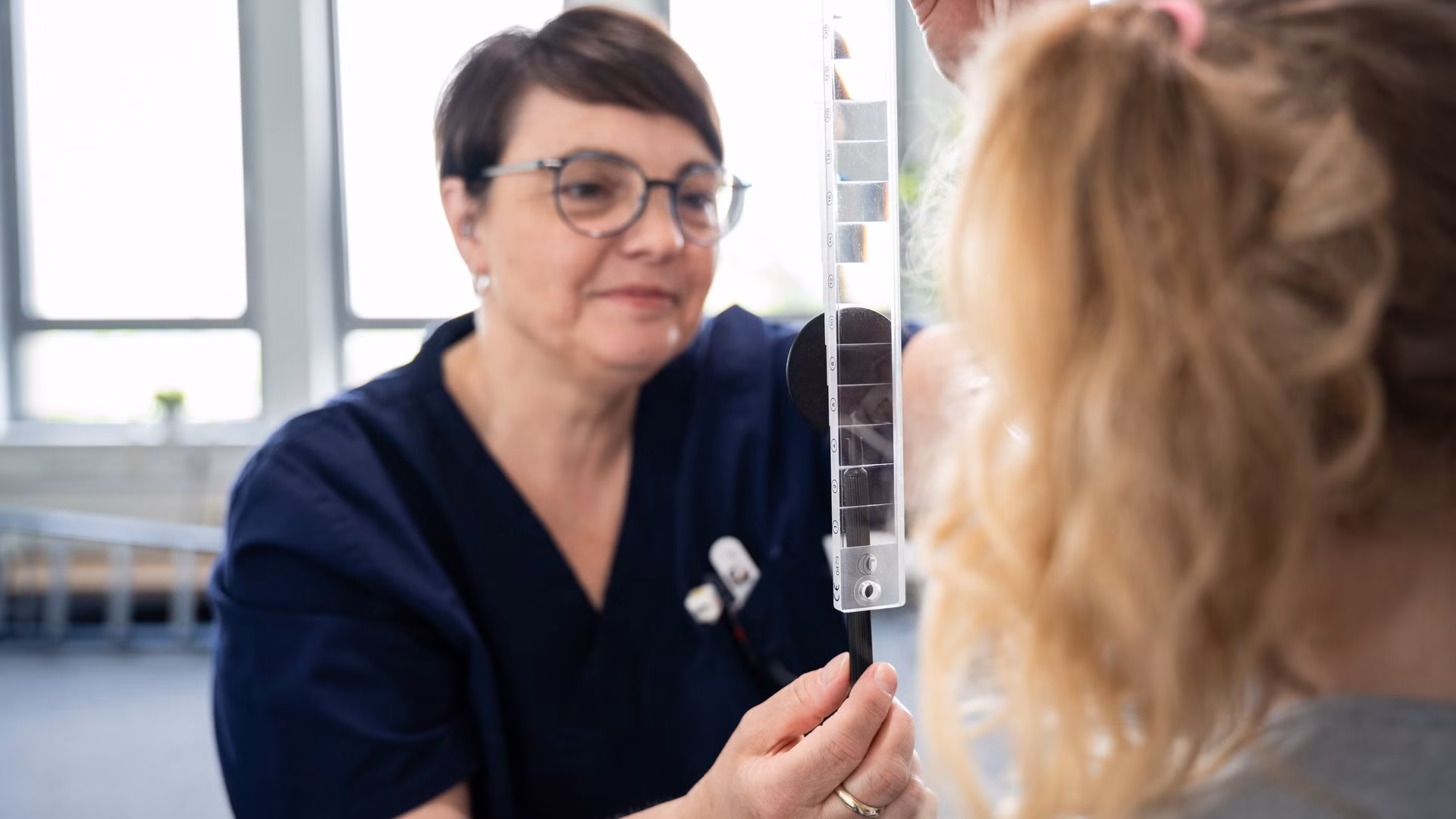 Orthoptistin führt Augenuntersuchung bei Kind durch