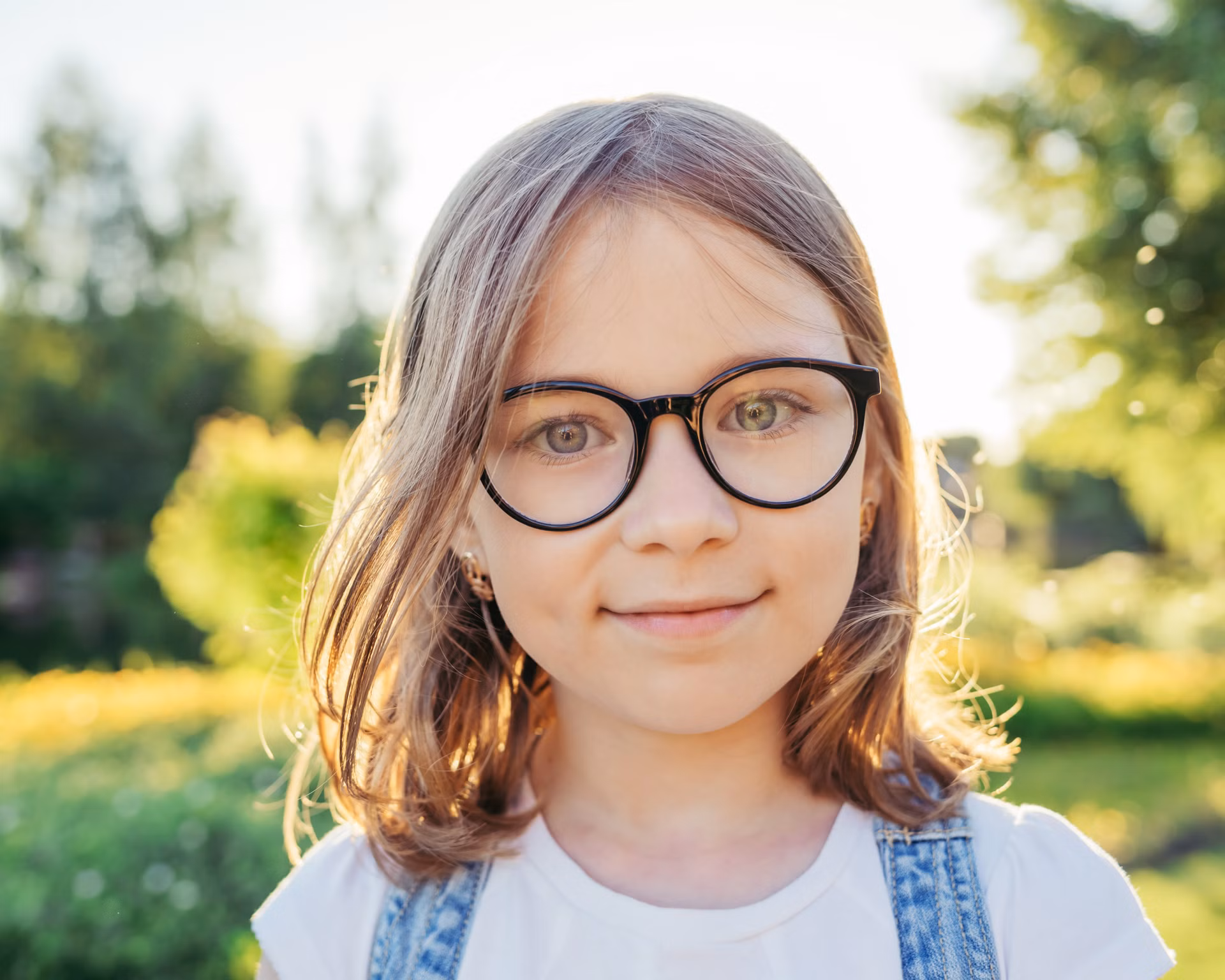 Mädchen mit Anisometropie trägt eine schwarze Brille