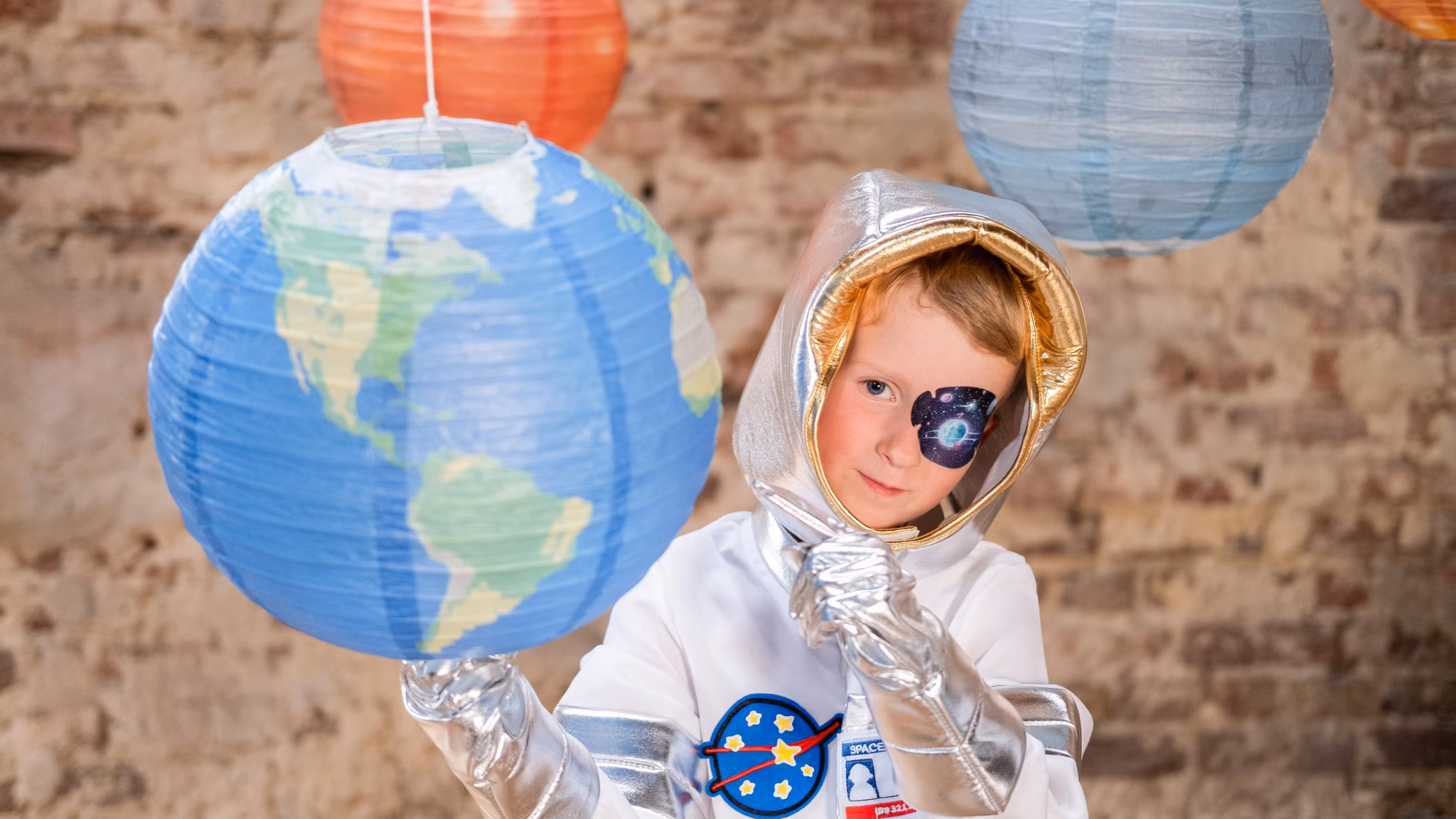 Kind mit Augenpflaster und Globussen