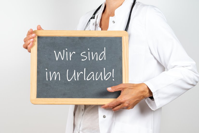 Arzt mit einer Tafel Wir sind im Urlaub