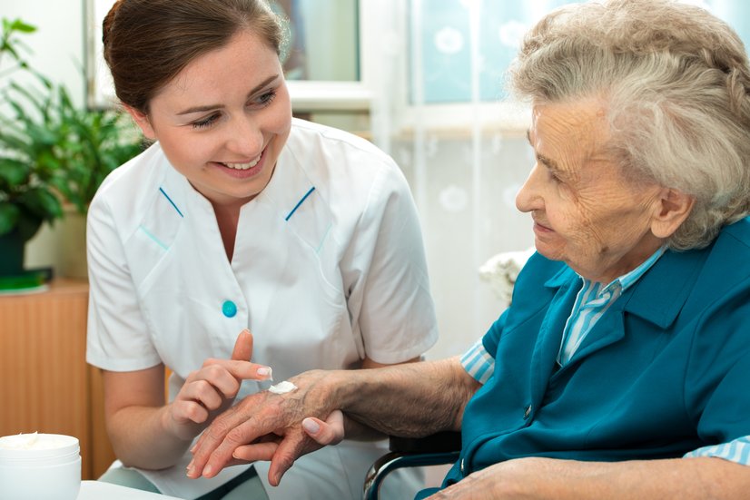 Pflegerin versorgt Seniorin
